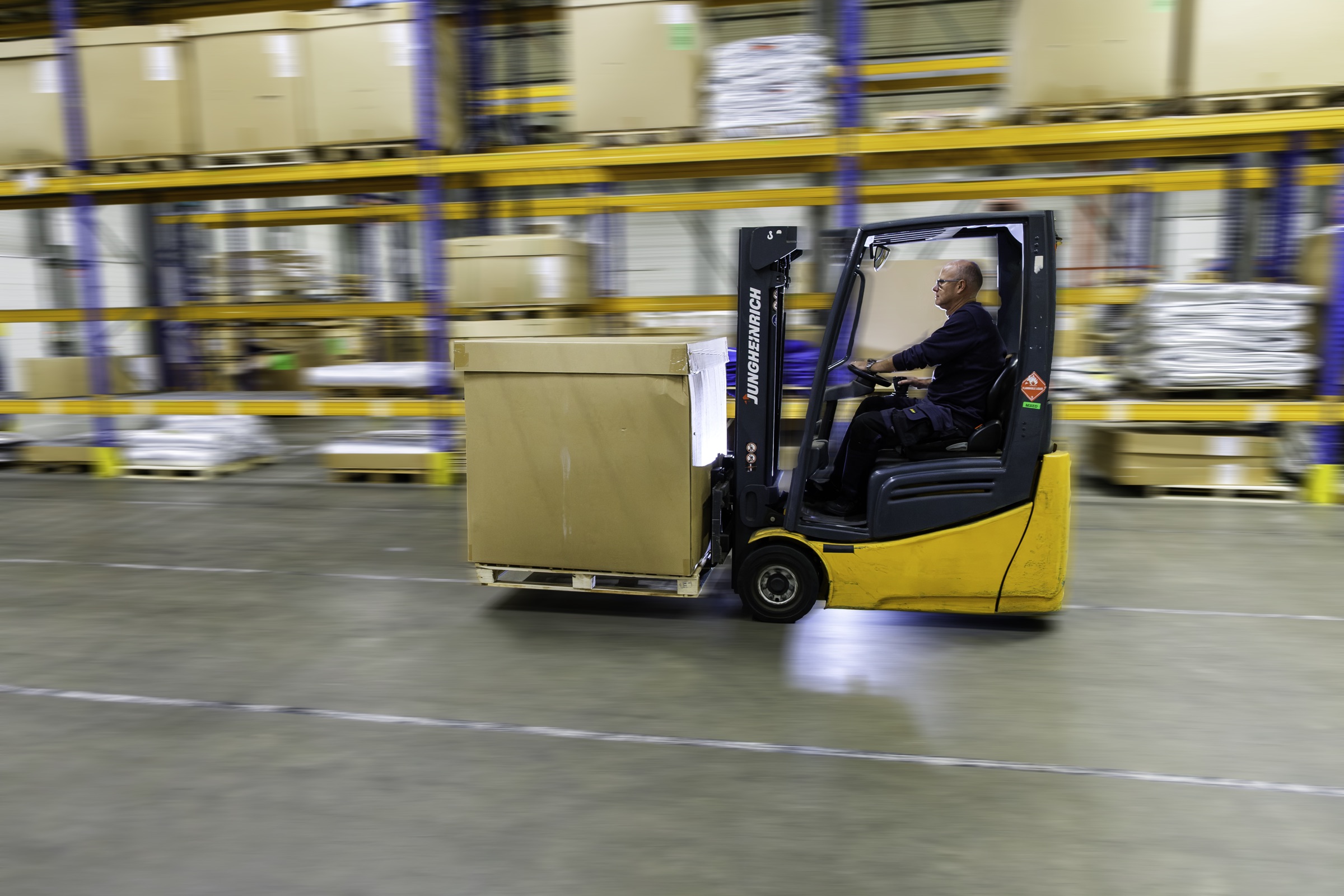 LOGI-FIX warehouse operator transporting goods by forklift